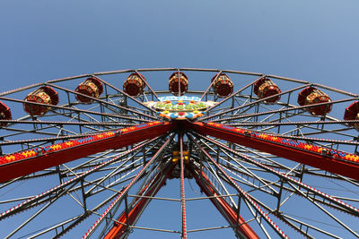 Low angle view of ferris wheel against clear blue sky