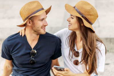 Smiling friends using mobile phone