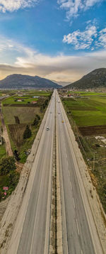 Road leading towards landscape against sky