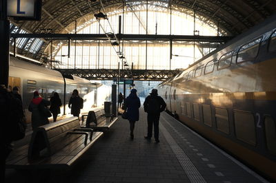 Rear view of friends walking at railroad station platform