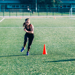 Full length of woman running on field