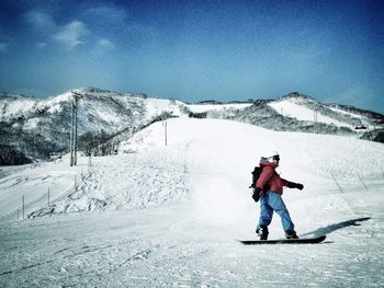 Rear view of woman standing on snow covered mountain