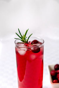 Cranberry juice in a glass on a table with a white tablecloth