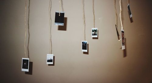 Close-up of photos hangings against wall at home