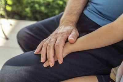 Midsection of couple holding hands