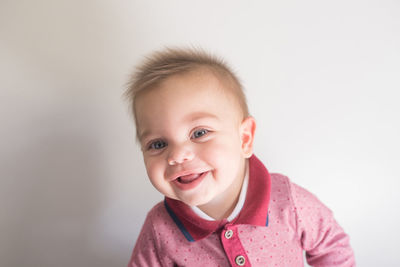 Portrait of cute baby boy against white background