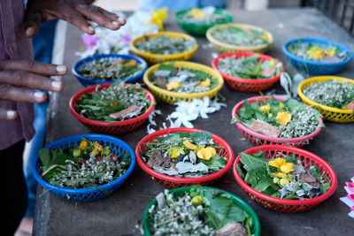 High angle view of hands over religious offerings for sale at market