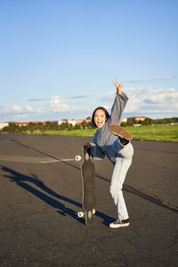 Full length of young woman standing on road