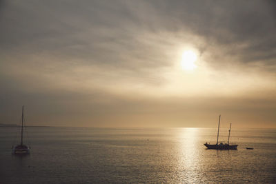 Sailboat sailing on sea against sky during sunset