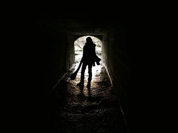 Silhouette of man walking in tunnel