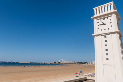 Scenic view of beach against clear blue sky