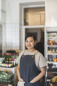 Portrait of a smiling young woman standing in store