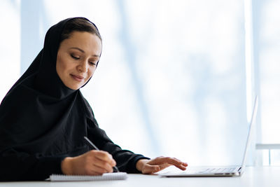 Young woman using laptop at home