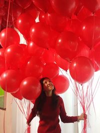 Low angle view of young woman with balloons