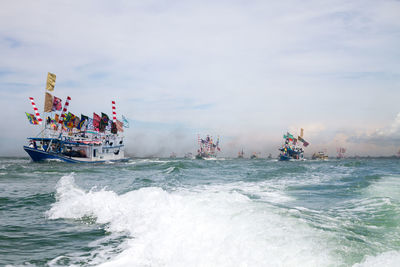 Boats sailing in sea against sky