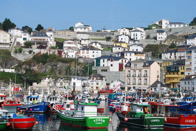 Boats moored by buildings against clear sky