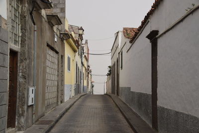 Empty alley amidst buildings in city