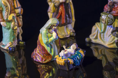 Close-up of figurine representing nativity scene against black background