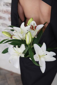 Midsection of woman holding white flowering plant