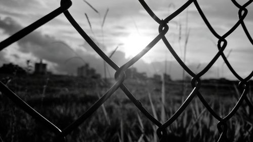 Close-up of chainlink fence against sky