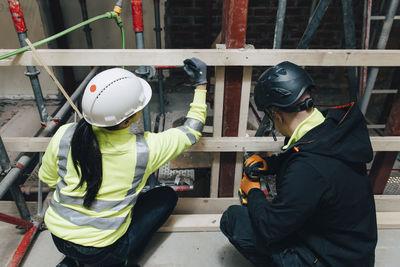 Male and female colleagues working together at construction site