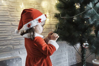 A mother and daughter decorate the christmas tree