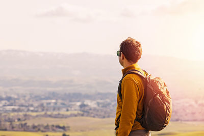 Side view of woman standing against sky