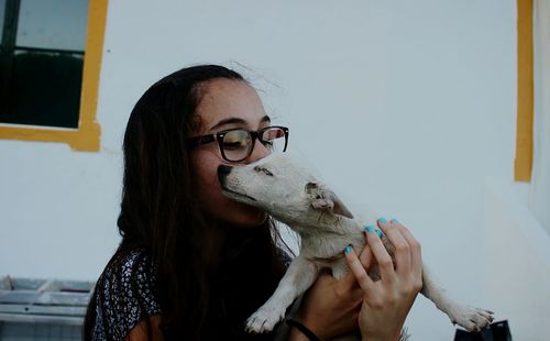 Girl kissing dog at home