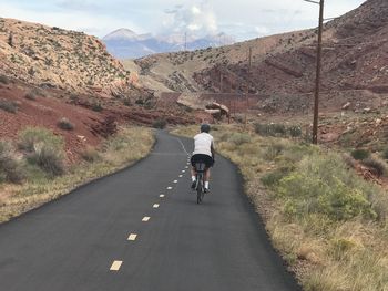 Rear view of man walking on road