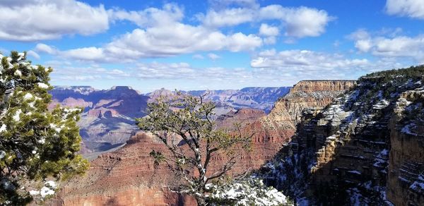 Panoramic view of trees and mountains against cloudy sky
