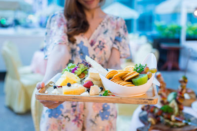 Midsection of woman holding fruits at market