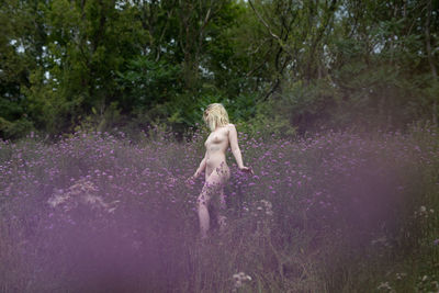 Full length of woman standing in forest