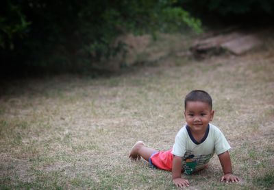 Portrait of boy sitting on field