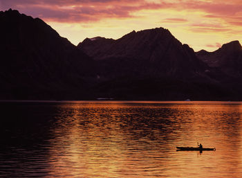 Man traveling on a sea-kayak though the fjords of eastern greenland