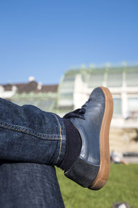 Low section of person against blue sky