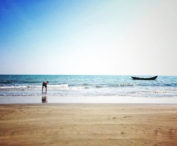 Man standing on beach against clear sky