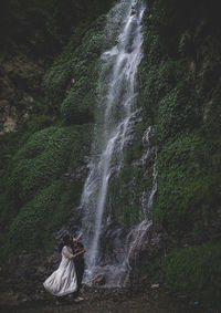 Woman on waterfall in forest