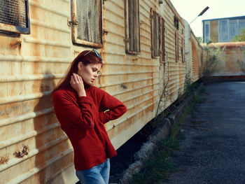 Young woman standing against building