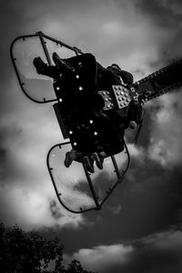 Low angle view of chain swing ride against sky