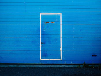 Closed blue door on corrugated iron