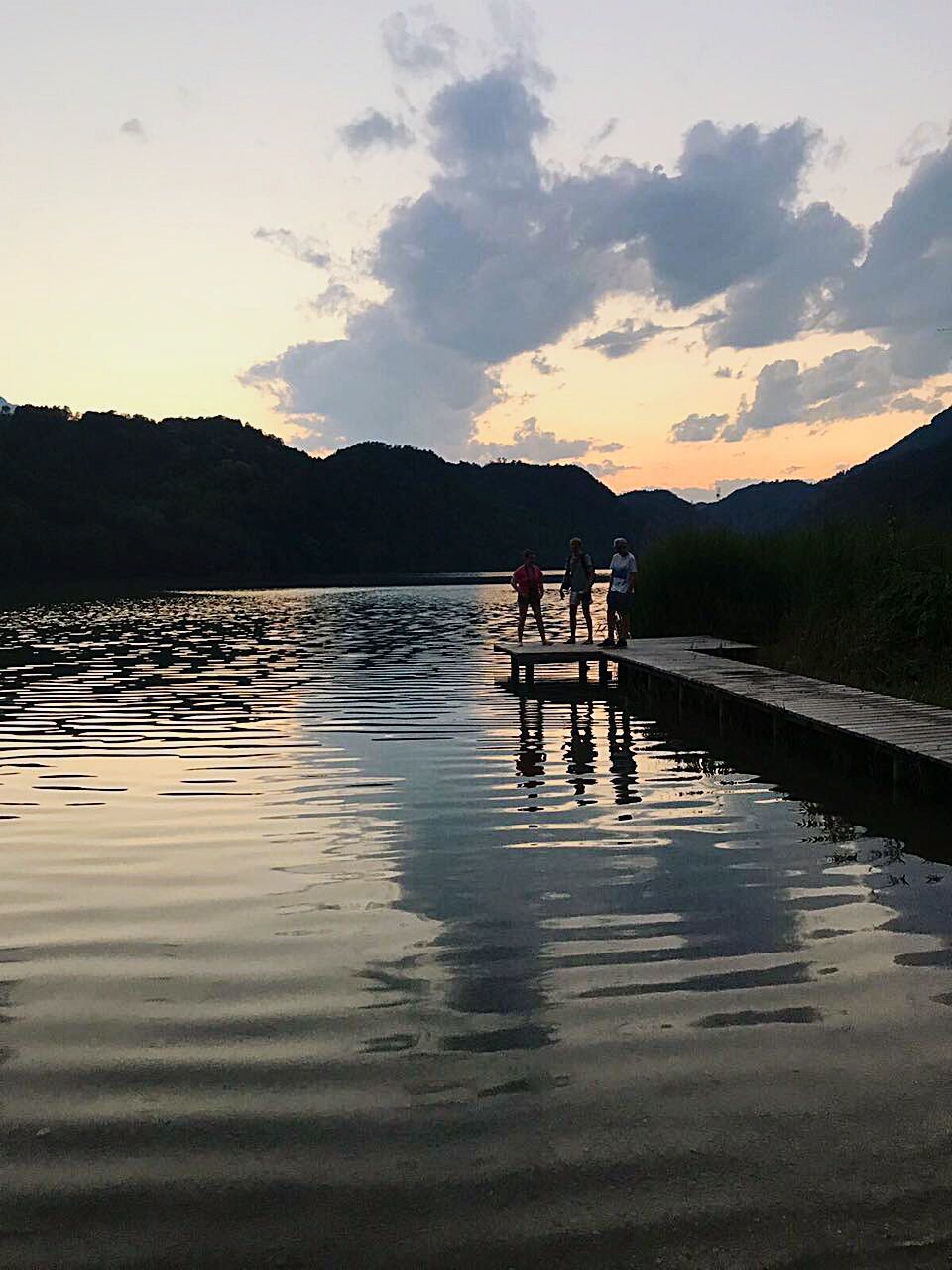 reflection, water, lake, sunset, nature, beauty in nature, sky, silhouette, scenics, tranquility, mountain, tranquil scene, real people, outdoors, men, two people, tree, day, people