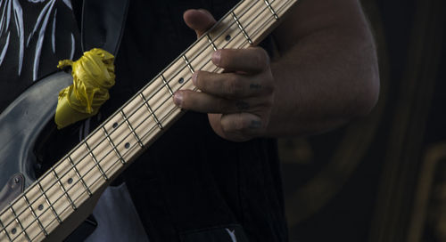 Midsection of man playing guitar