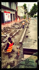 Rear view of people working on street