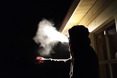 Young man smoking at night