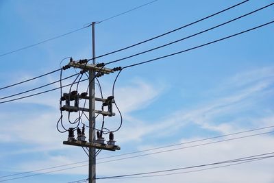 Low angle view of electricity pylon against sky