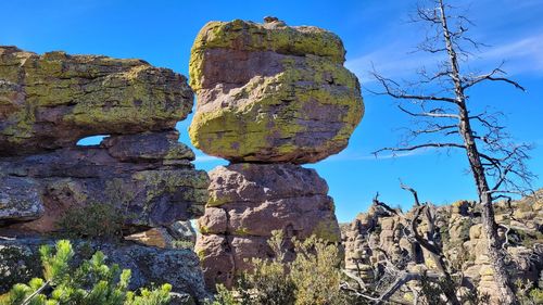 Low angle view of rocks against blue sky