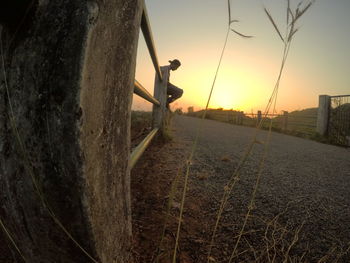 Man on field against sky during sunset