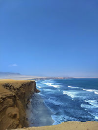 Scenic view of beach against blue sky