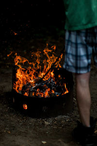Low section of person standing by bonfire