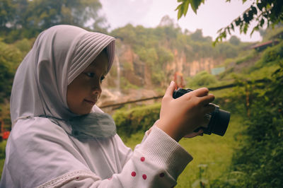 Young woman photographing with powershot camera